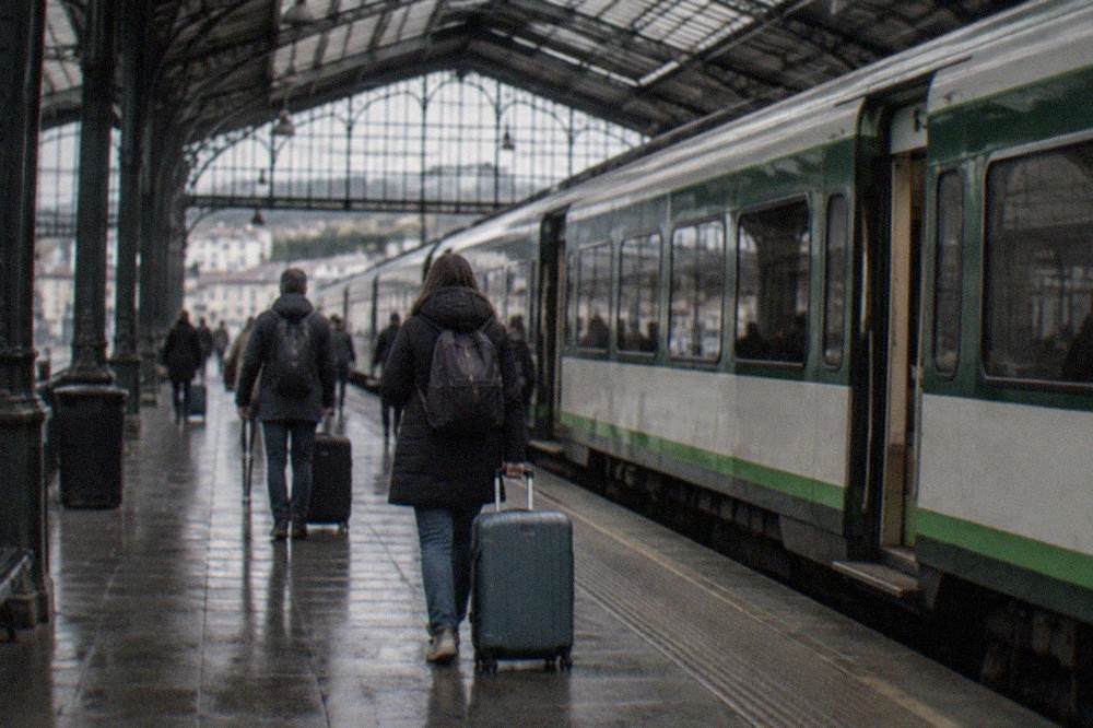 A long-distance train platform in Spain with a green and white regional train waiting