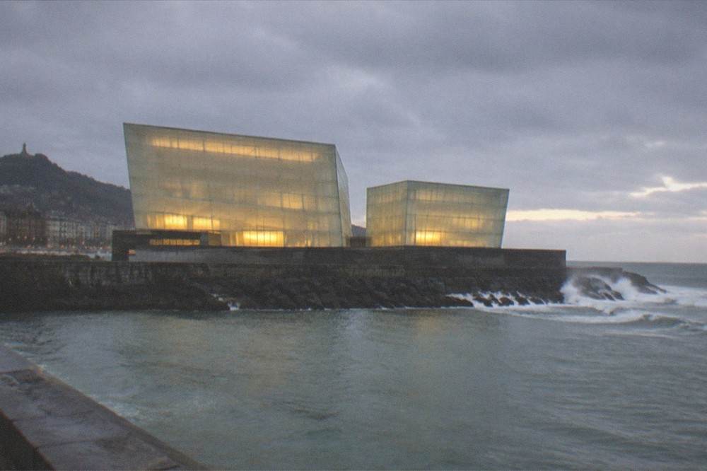 The illuminated Kursaal concert hall cubes beside the Urumea river mouth at dusk in San Sebastián