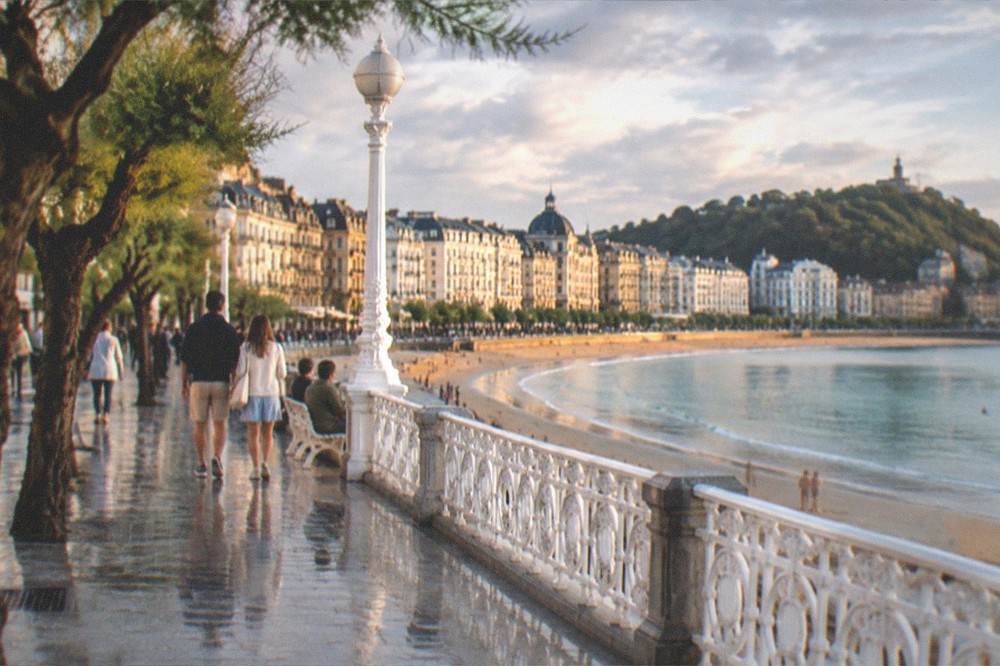 A calm summer evening on La Concha bay with the promenade and beach in warm light
