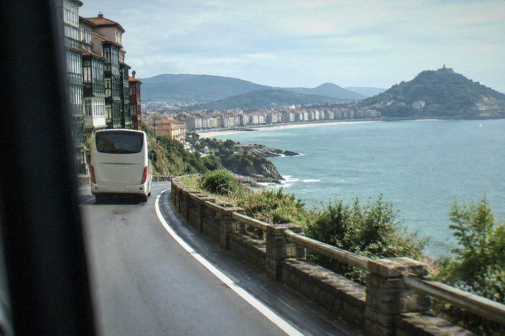 A coach on a coastal road approaching San Sebastián from Bilbao