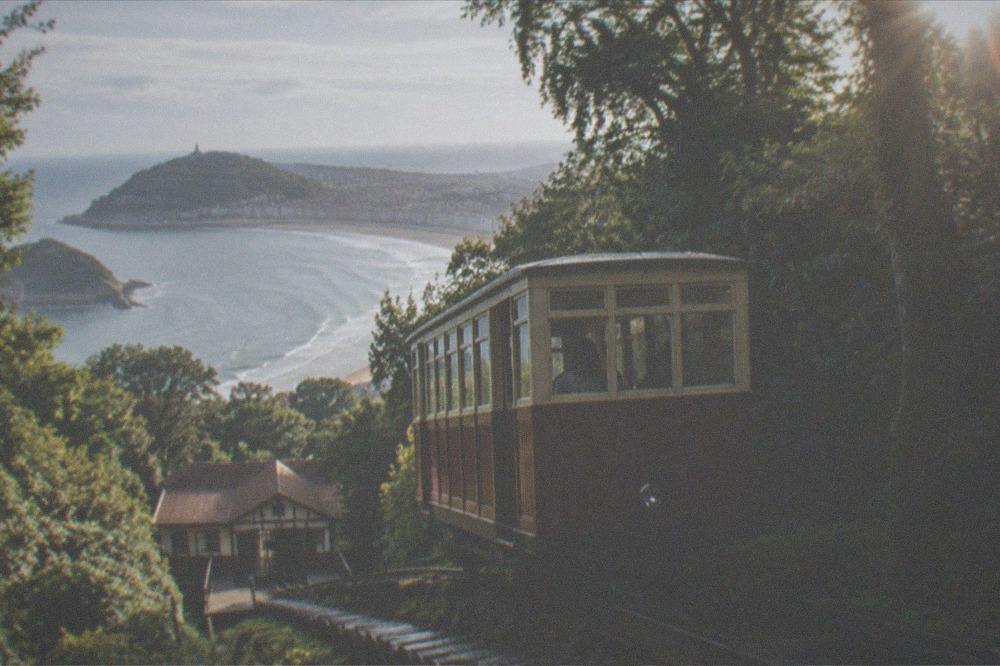 The Monte Igueldo funicular with wooden cars climbing the wooded hillside