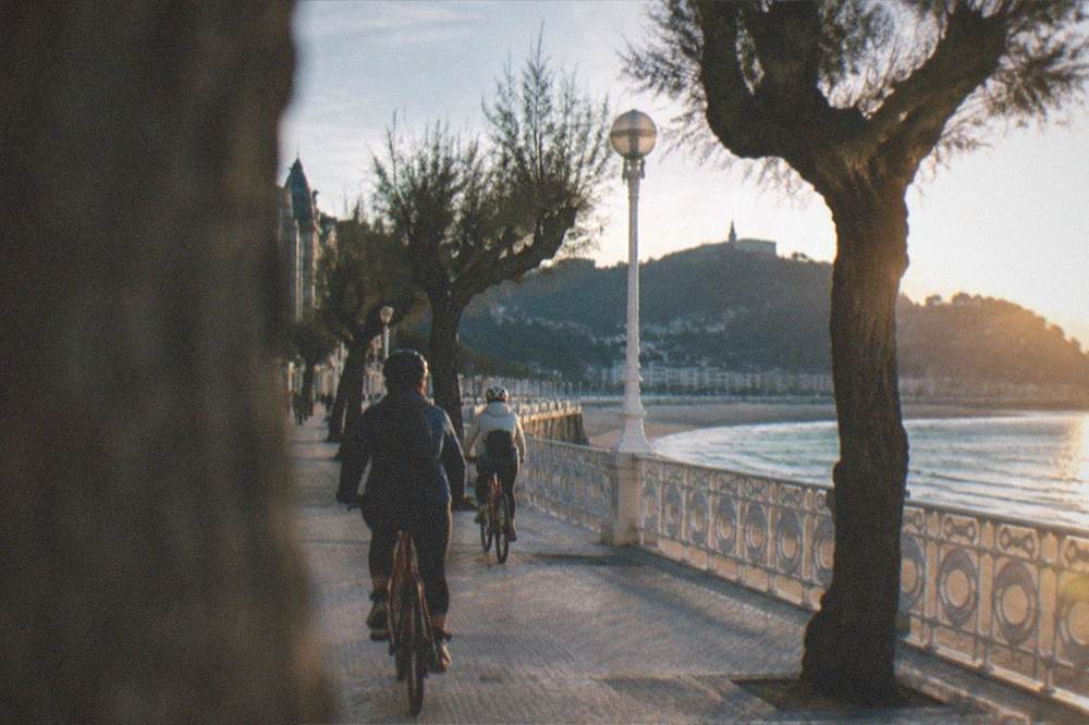 Cyclists riding along the La Concha promenade toward Monte Igueldo