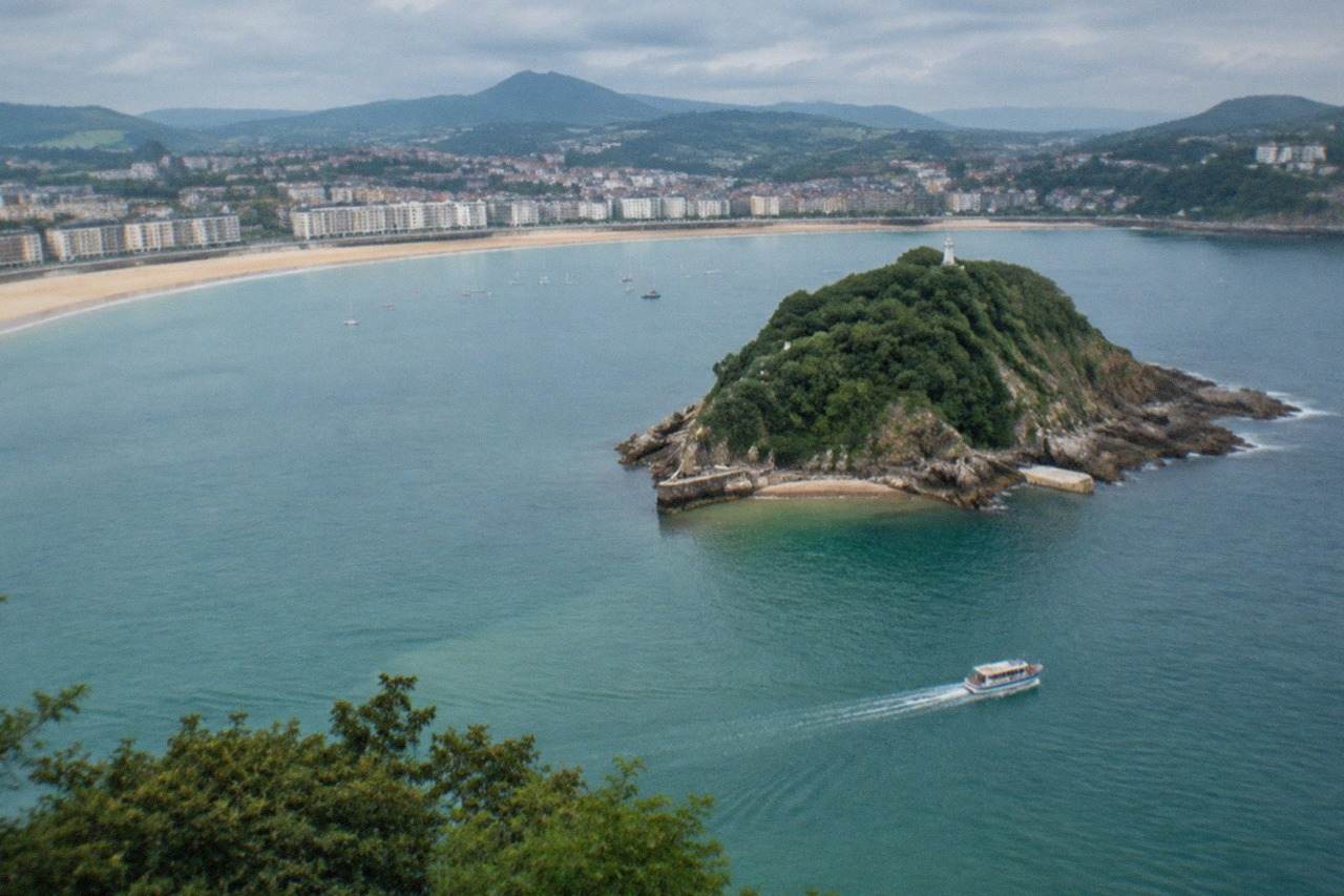 The wide sandy curve of La Concha beach in San Sebastián with Santa Clara island offshore
