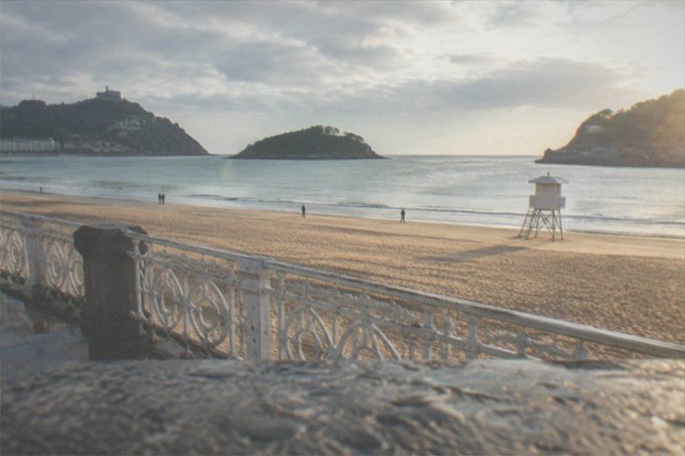 A lifeguard watchtower on the sand at La Concha with the bay behind it