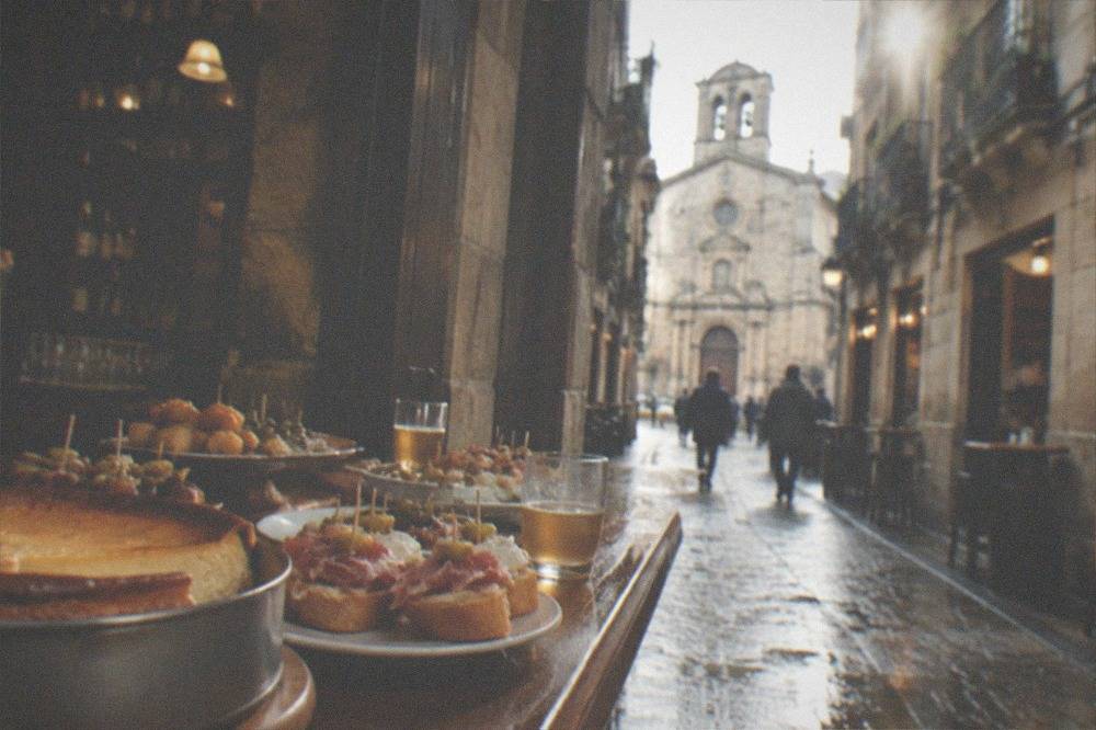 A bar counter in an Old Town cider bar with pintxos and a whole cheesecake tin displayed