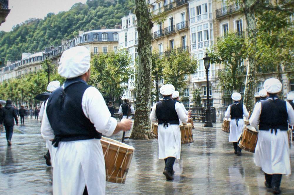 Drummers in 19th century cook costumes marching through the Old Town of San Sebastián