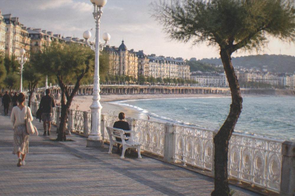 Hotel facades and balconies above the seafront promenade of San Sebastián at dusk