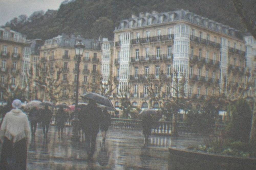 People in traditional Basque rural dress walking through a decorated city square
