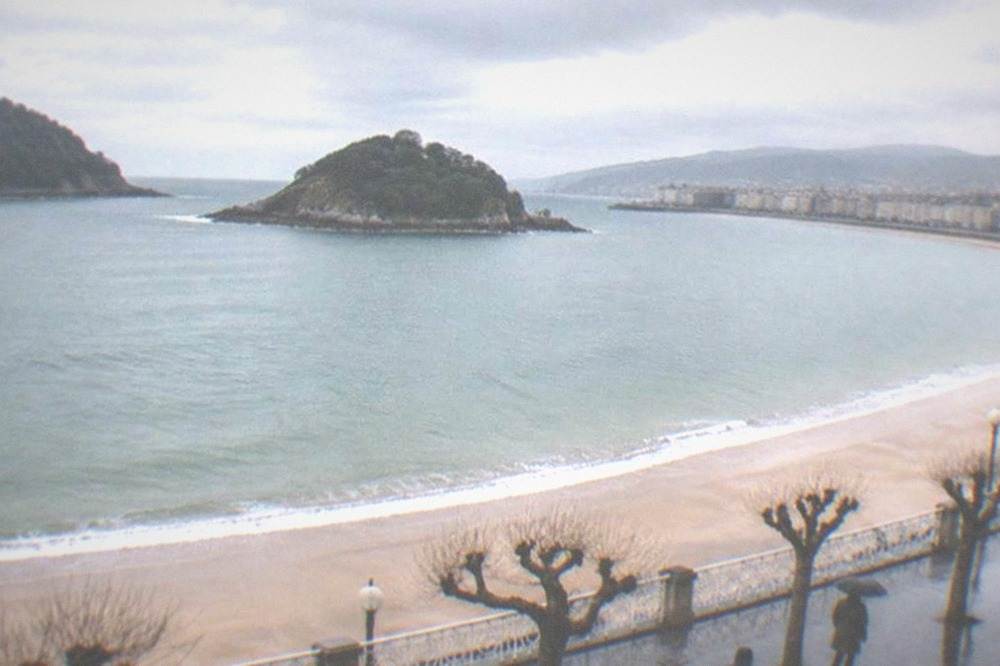 A view along La Concha bay in winter light with the island and empty sand