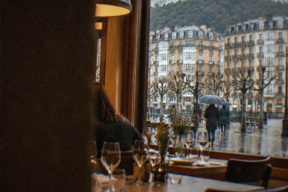 A warm restaurant interior in the Basque Country with set tables and wine glasses