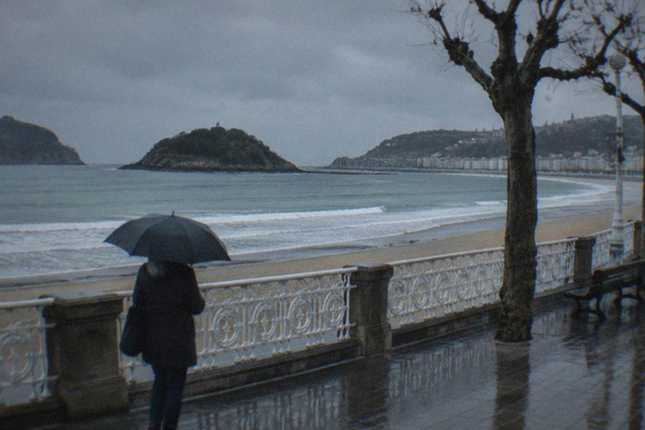 Waves breaking on the empty sand of La Concha bay under a grey winter sky