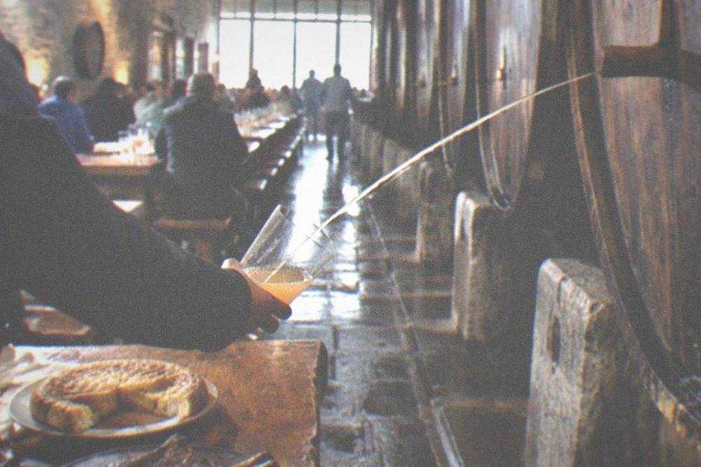 A cider house dining room with long wooden tables set for a winter meal