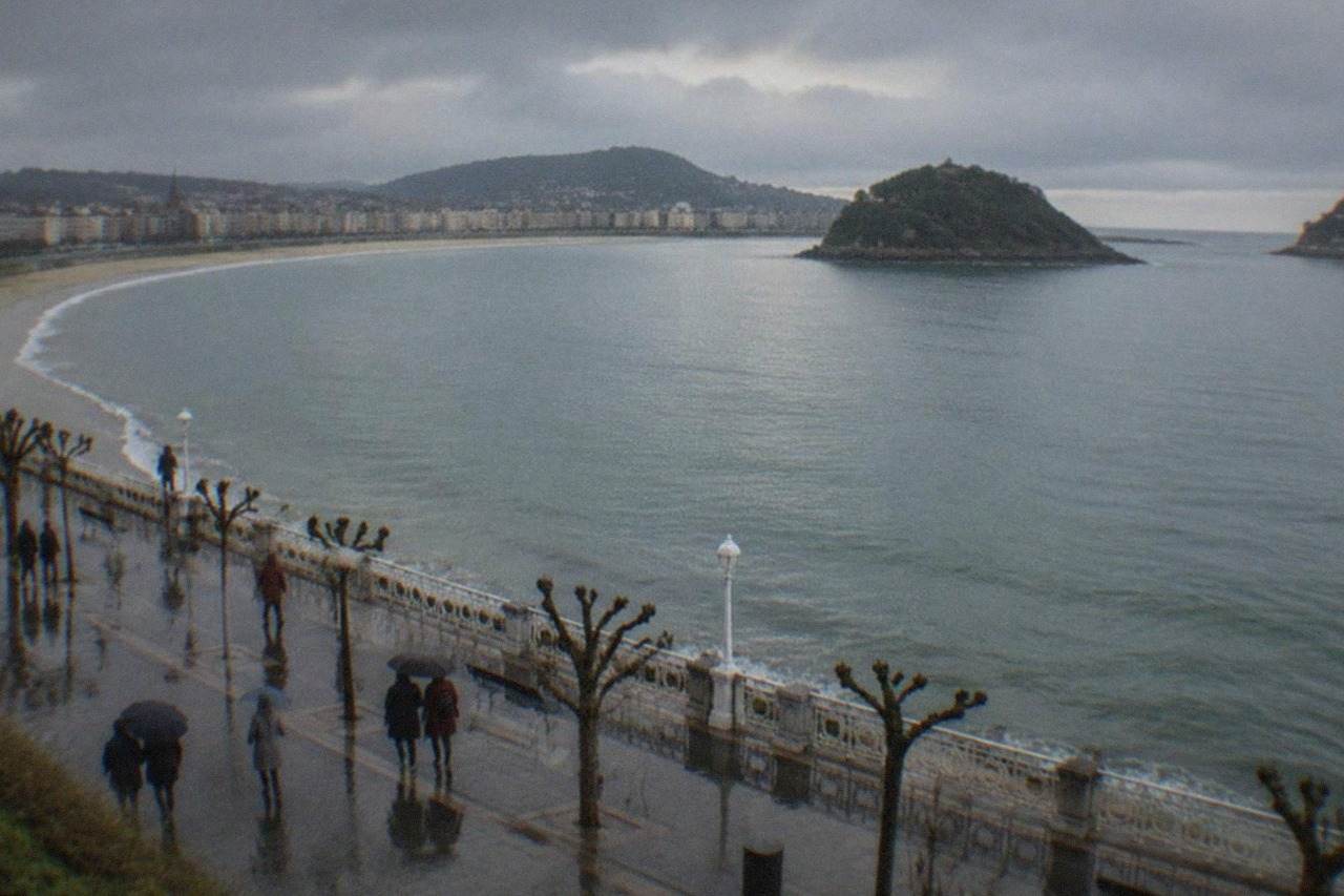 The curve of La Concha bay seen from above on a calm winter morning, with the beach promenade and Santa Clara island in the distance