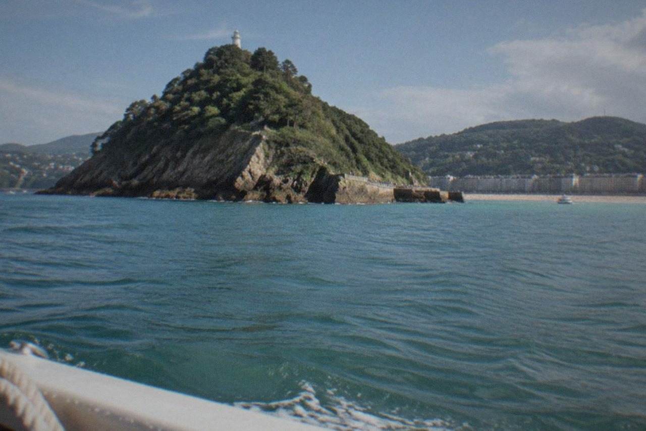La Concha bay in San Sebastián on a bright summer day with Santa Clara island and green hills behind the beach