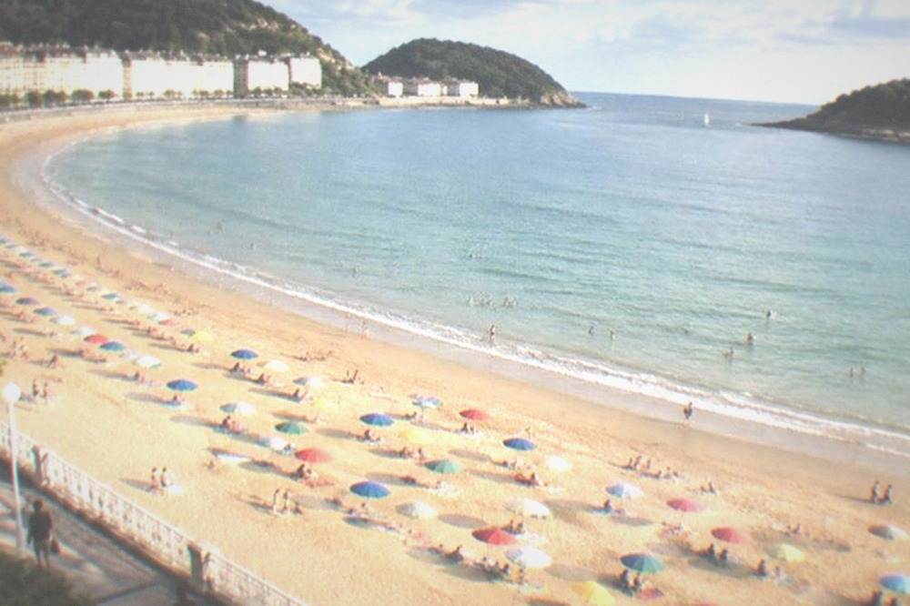 Rows of coloured awnings and parasols on La Concha beach in San Sebastián on a sunny July day