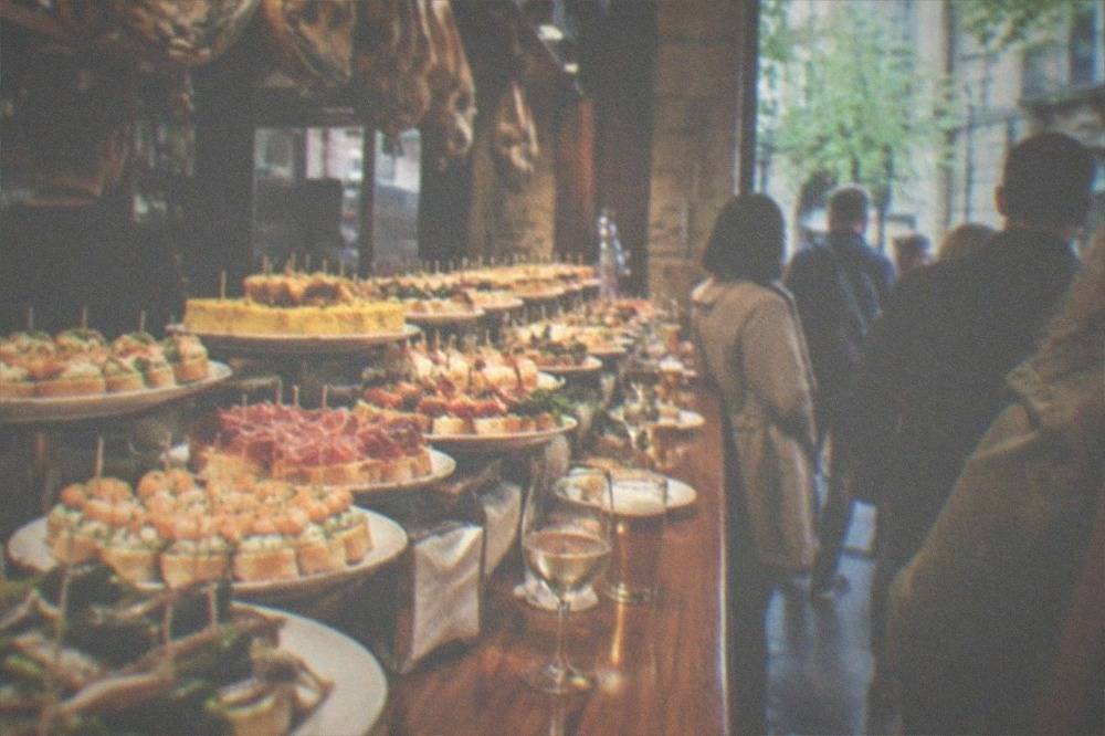 A pintxo bar counter in San Sebastián loaded with small skewered snacks