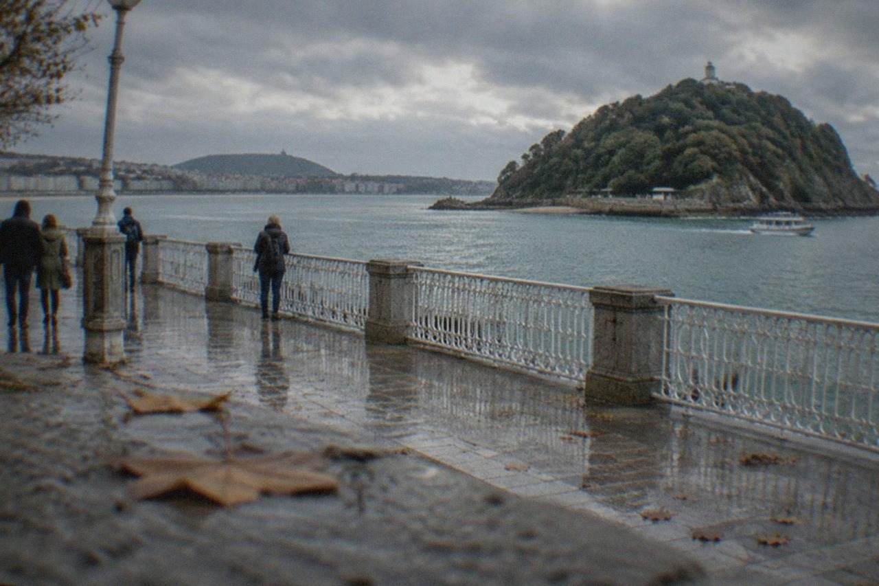 The La Concha bay promenade in San Sebastián under a grey November sky, with the Santa Clara island offshore