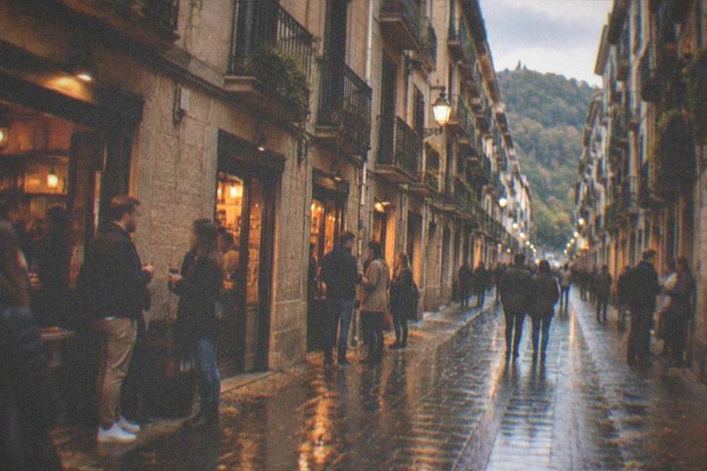 Evening light on the Parte Vieja old quarter of San Sebastián with wet streets reflecting bar windows