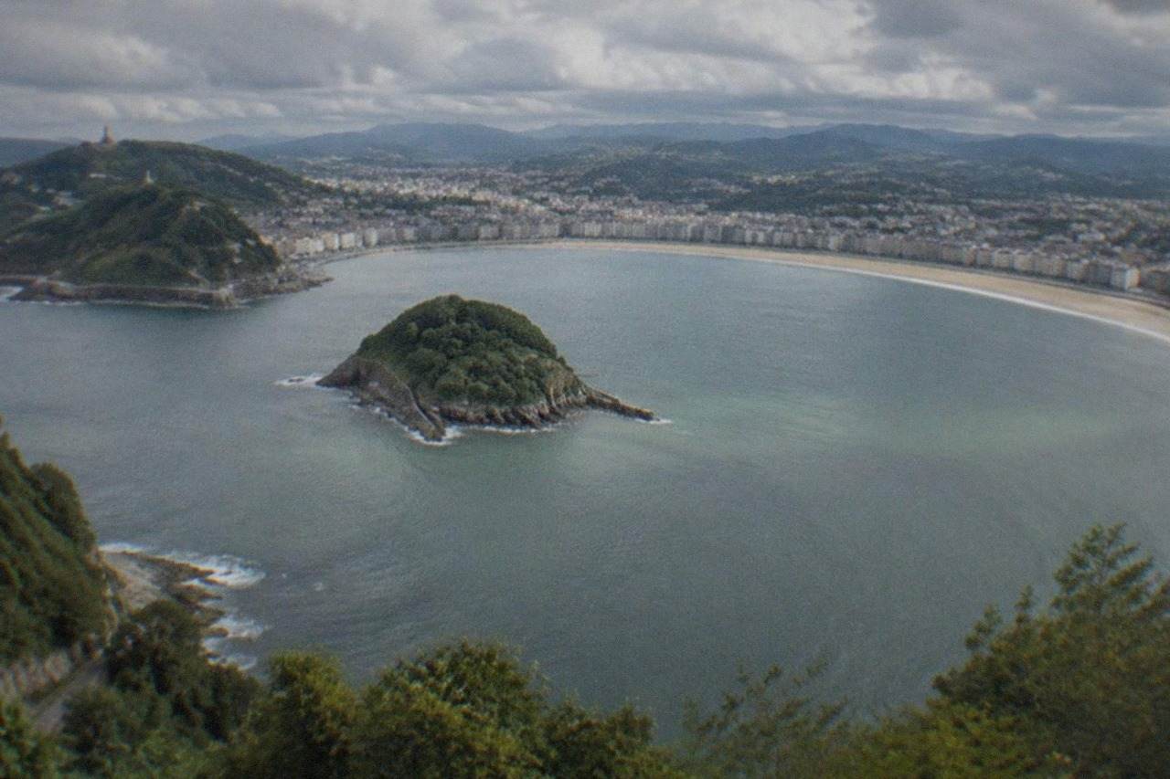 Aerial view of La Concha bay in San Sebastián with the island and green hills around the water