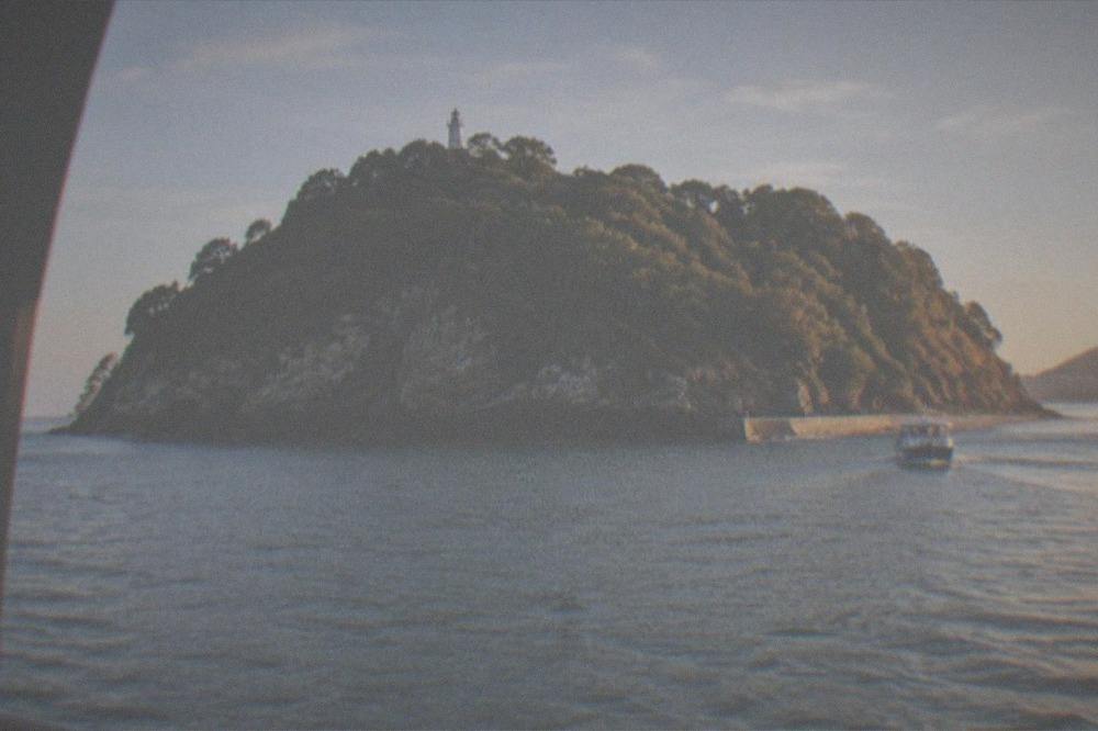 Santa Clara island seen across the water with the lighthouse among trees