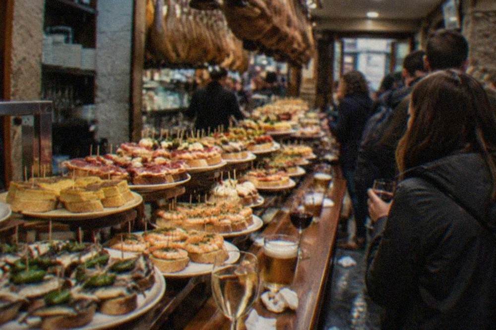 Crowded pintxo bar counter in the Old Town of San Sebastián at night