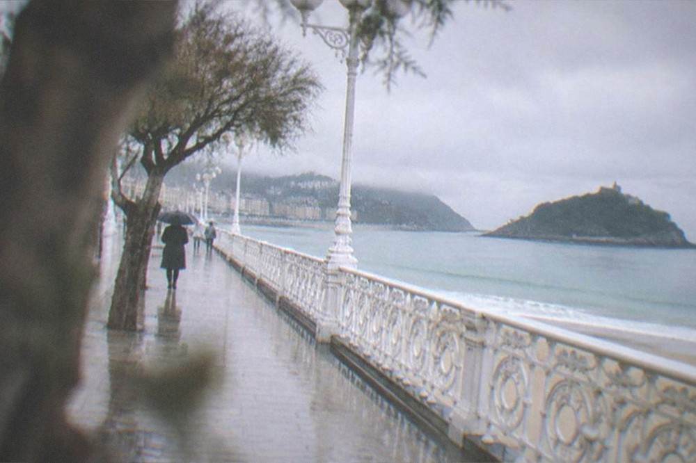 The white promenade railing of La Concha leading toward Santa Clara island in early morning light