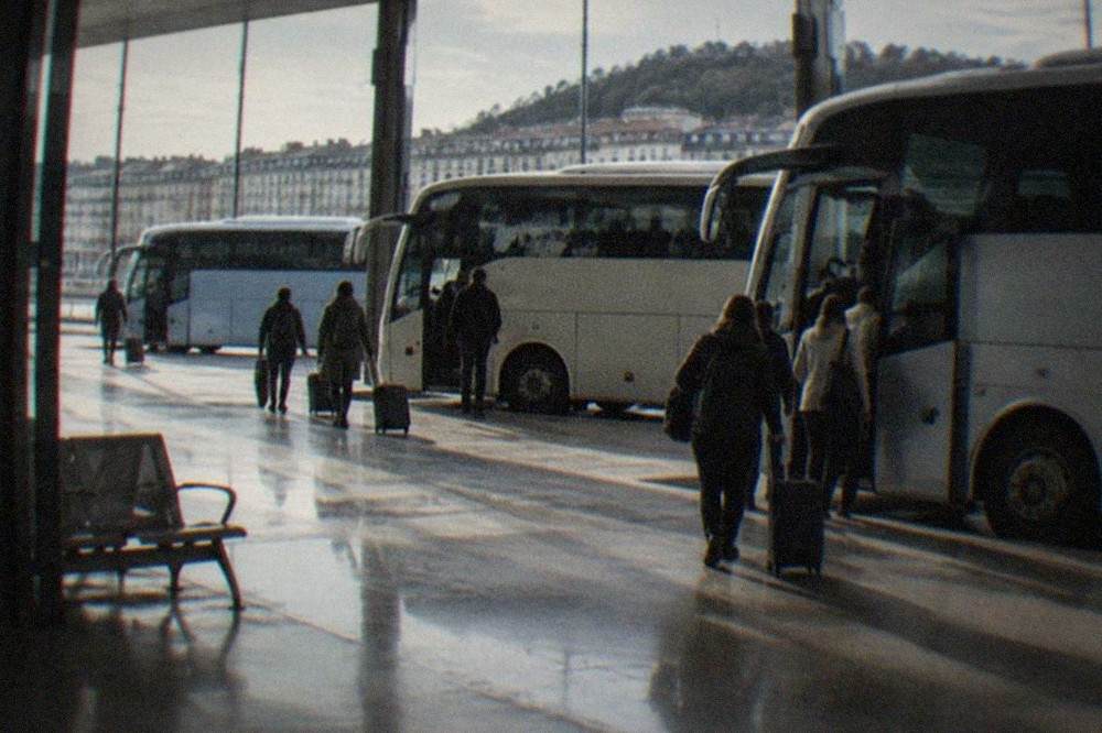 Coaches parked at a city bus station with passengers boarding