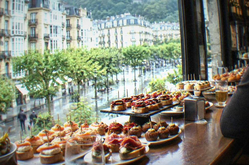 A counter of small pintxo skewers and plates in a Basque bar in San Sebastián