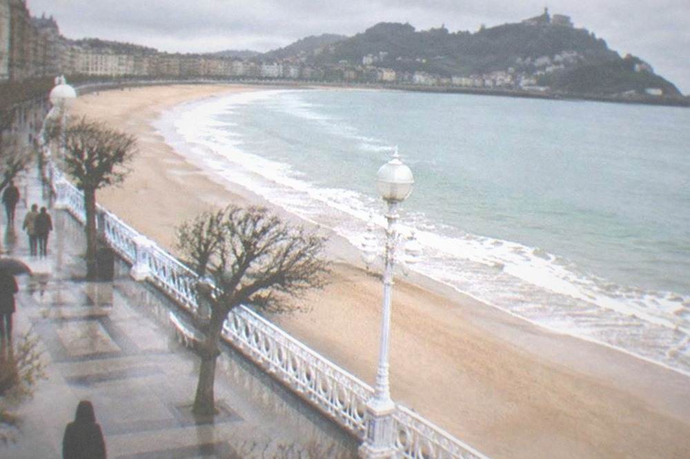 The promenade and railing of La Concha with the bay curving toward Monte Igueldo