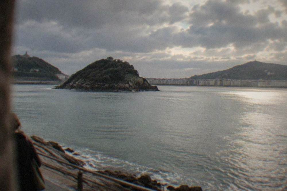 Dark Atlantic clouds passing over La Concha bay with sun breaking onto the water