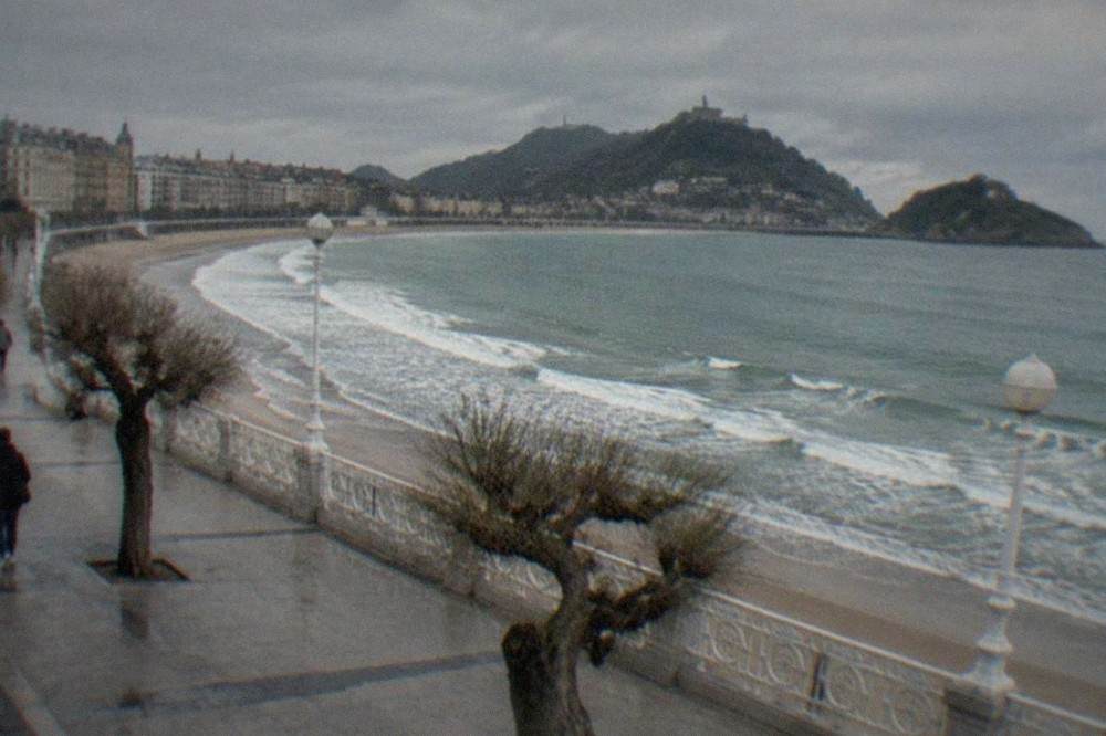 Waves breaking along the La Concha promenade in San Sebastián under a grey Atlantic sky