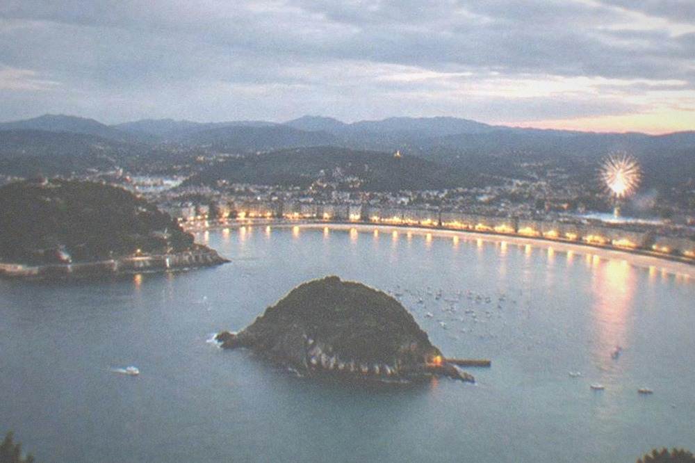 La Concha bay seen from above at dusk with the beach, island and city lights before a fireworks night