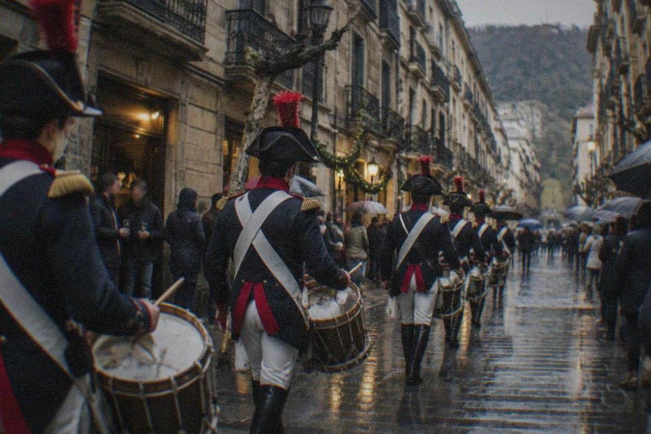 Drummers in Napoleonic uniform marching through a decorated old town street at dusk