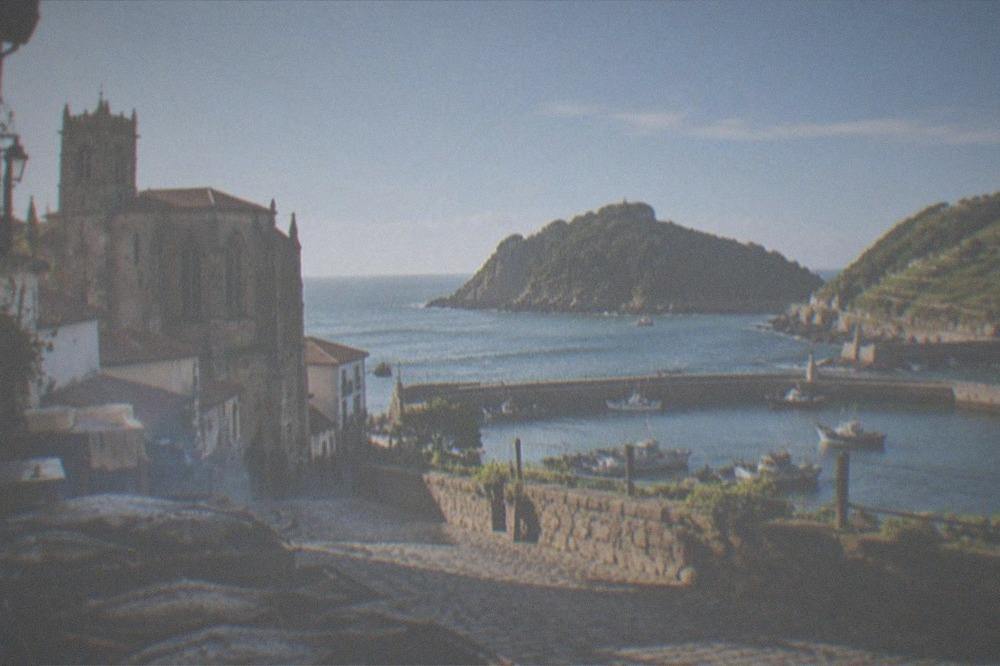 The harbour and headland of Getaria with green vineyard slopes behind