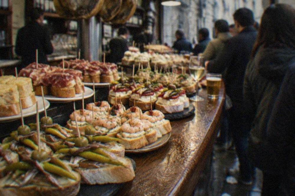 Close view of pintxos held with skewers on a bar top in the Basque Country