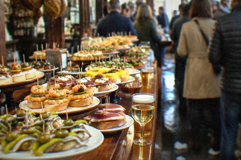 Pintxos with anchovies, peppers and olives on skewers on a bar counter