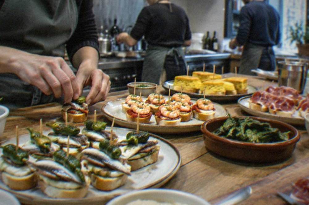A cooking class preparing Basque dishes at a kitchen counter