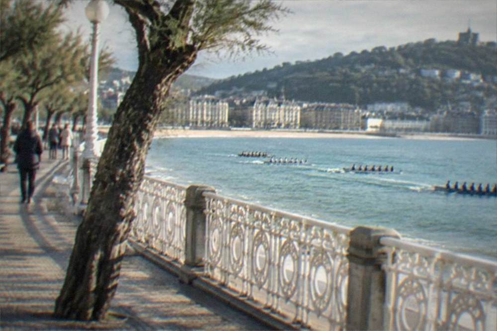 Rowing boats racing in La Concha bay watched from the promenade