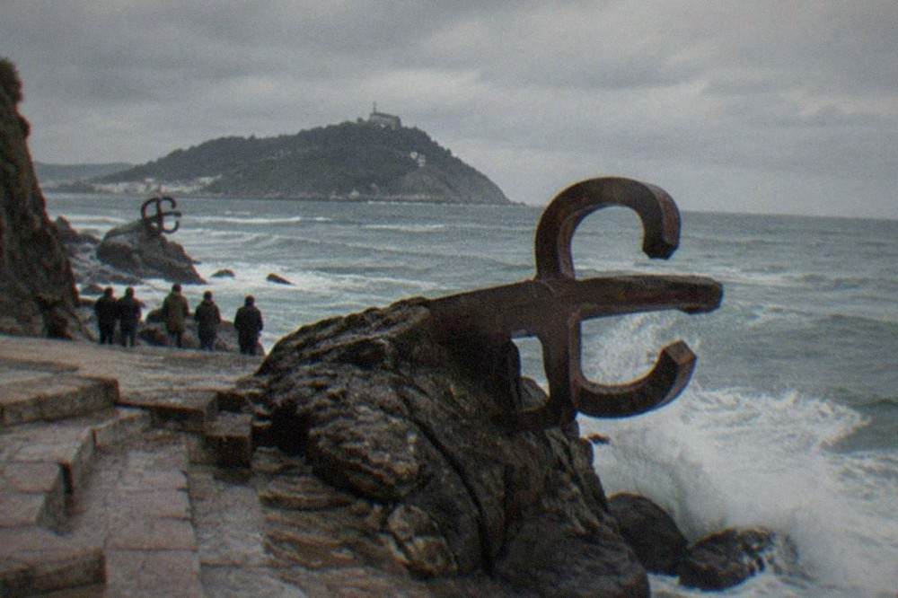 Waves breaking against the rocks at the Peine del Viento sculptures on a grey Atlantic afternoon