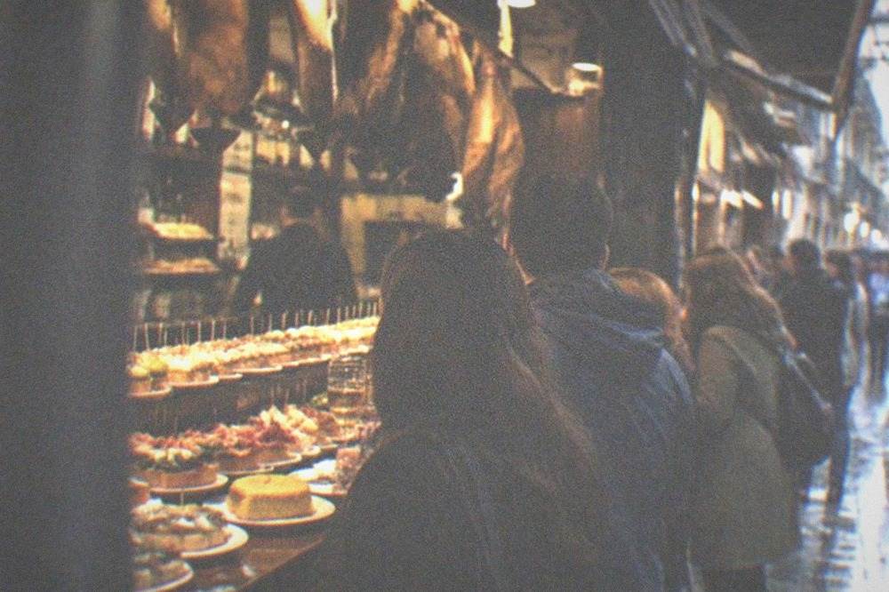 Crowded pintxo bars along a narrow street of the Parte Vieja in the evening