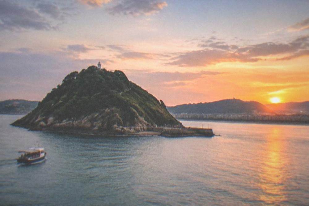 Sunset over La Concha bay with Santa Clara island and the coastline of Gipuzkoa in the distance