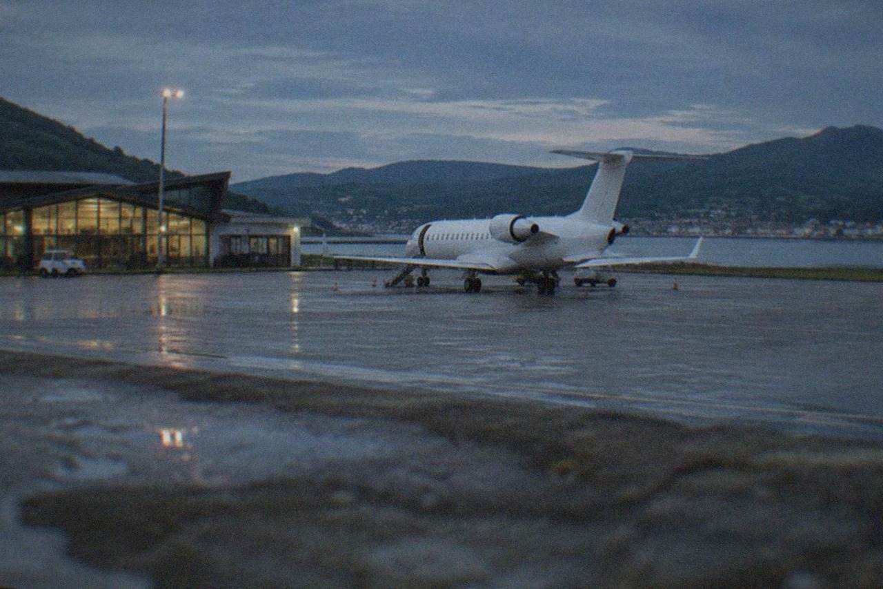 A small regional airport terminal beside green hills on the Basque coast
