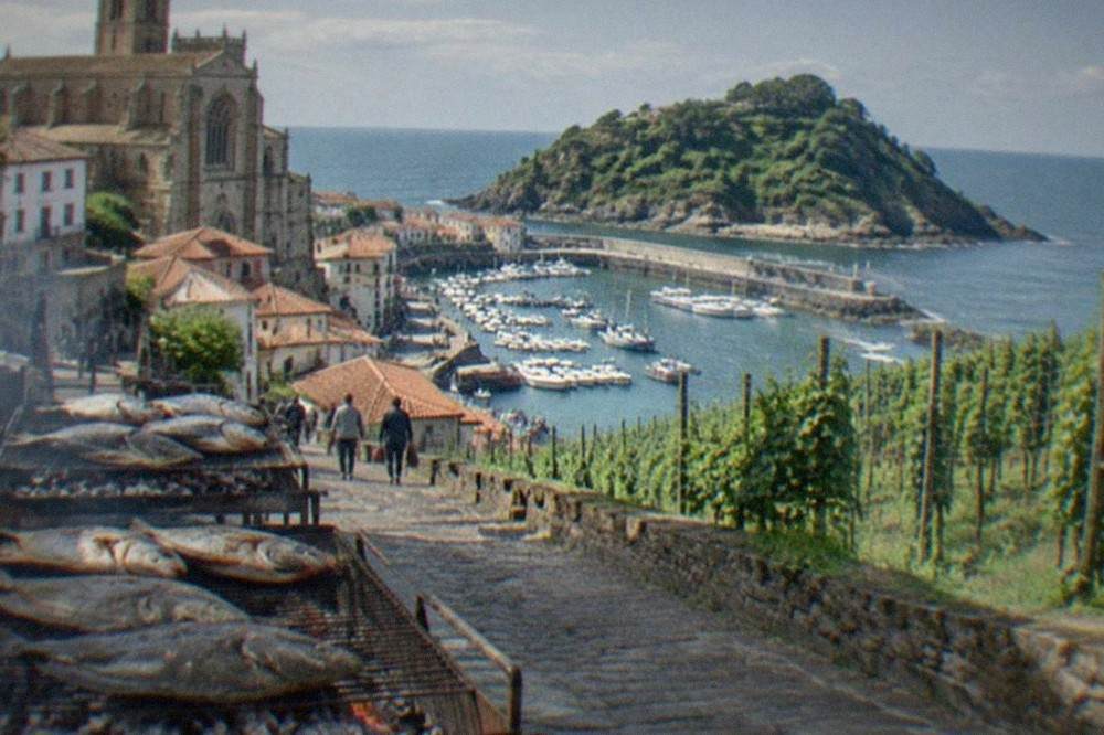 White boats in the small harbour at Getaria below the hilltop church