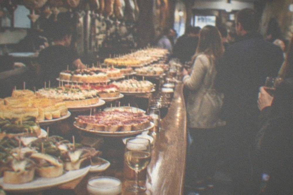 Pintxo bars in the Old Town of San Sebastián with crowds standing at the counter in the evening
