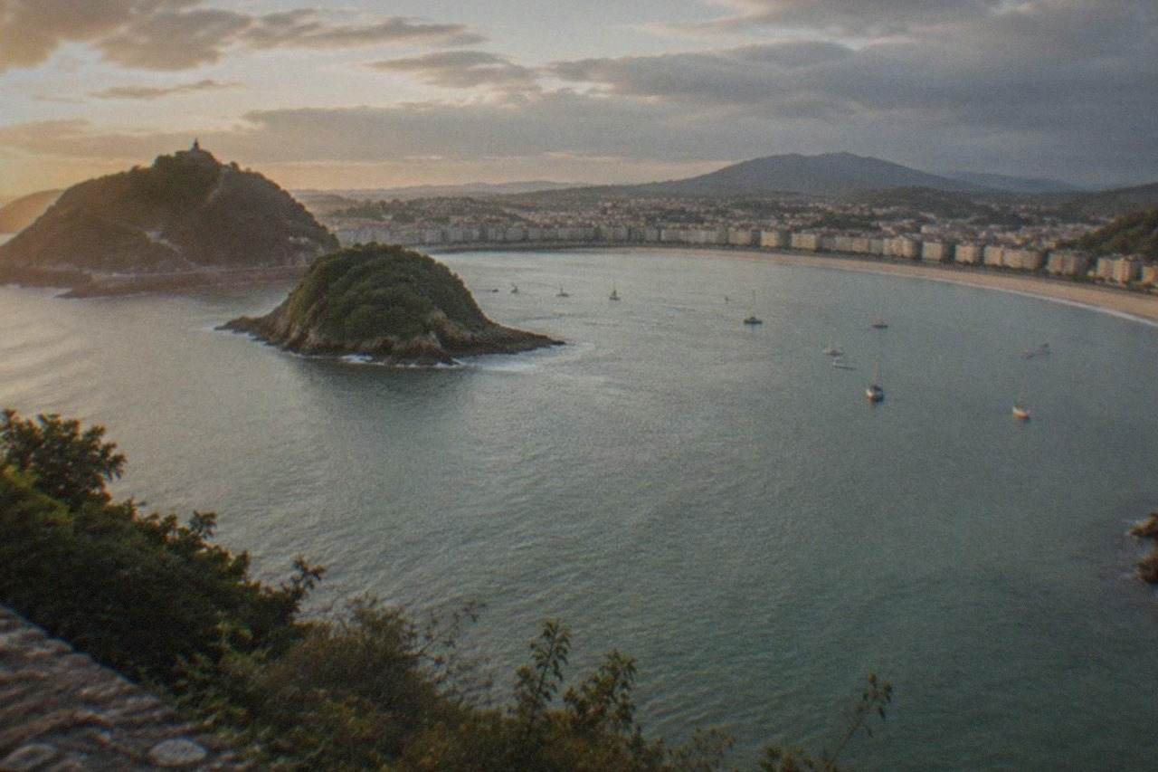 The curved sandy bay of La Concha in San Sebastián seen from above, with the island and hills on either side