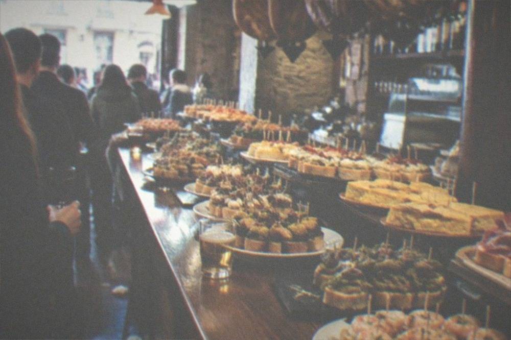 A pintxo bar counter in the Old Town of San Sebastián with small skewered dishes on display