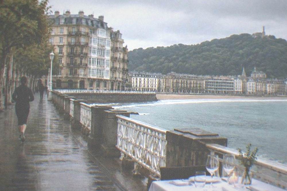 A table for two set for dinner in a San Sebastián restaurant with white tablecloth and bay view