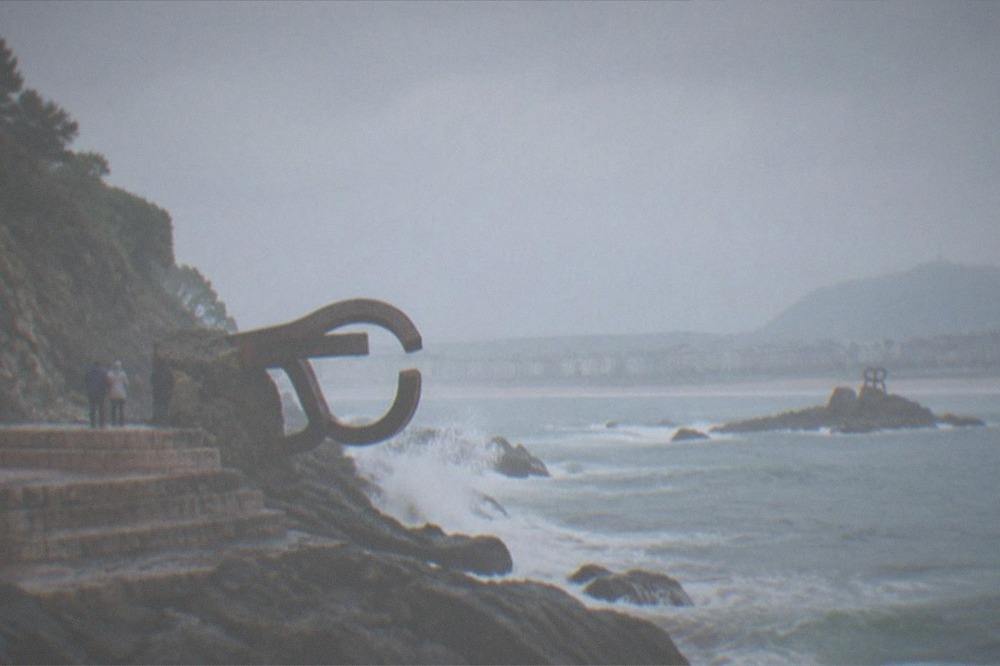Ondarreta beach at low tide with the Peine del Viento sculptures visible at the far end