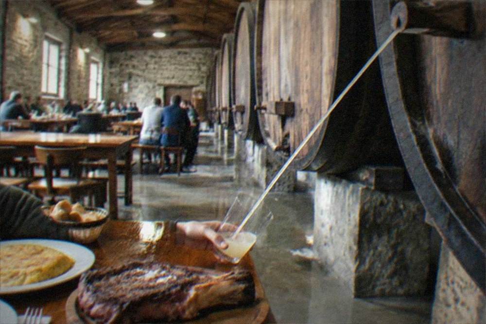 Cider pouring in a stream from a barrel at a Basque cider house