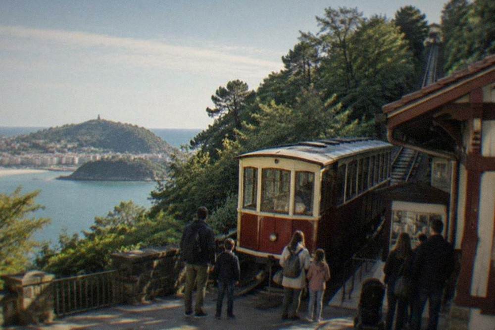 The wooden funicular car at the Monte Igueldo lower station with families waiting to board